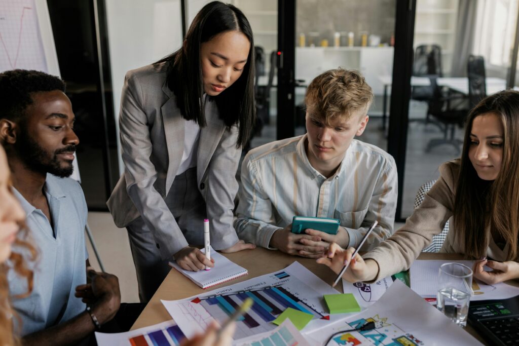 A young marketing professional discussing campaign ideas with a small team during a collaborative planning meeting.