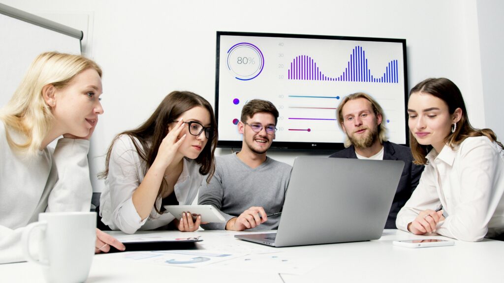 A small group of sales professionals gathered around a table.